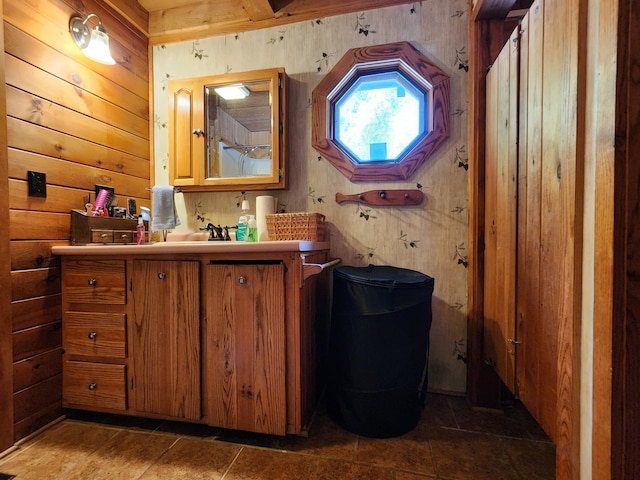 bathroom featuring wooden walls and vanity