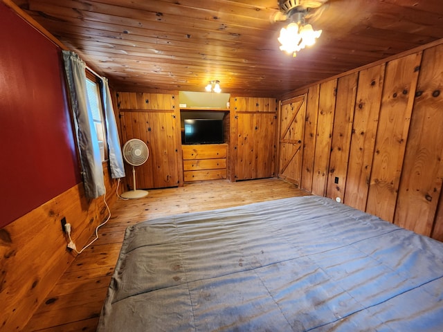 unfurnished bedroom featuring wooden walls, light hardwood / wood-style floors, and wood ceiling