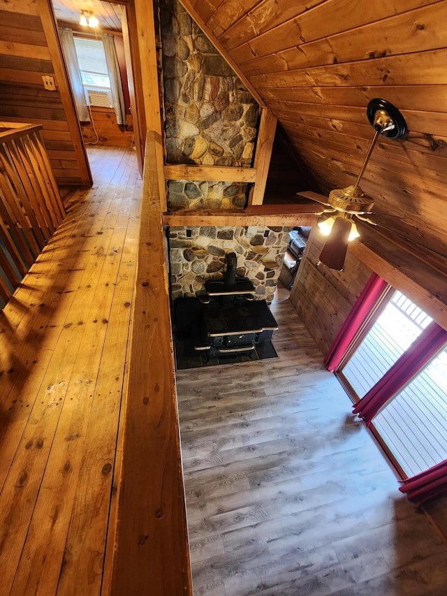 interior space featuring hardwood / wood-style floors, a wood stove, vaulted ceiling, and wooden ceiling