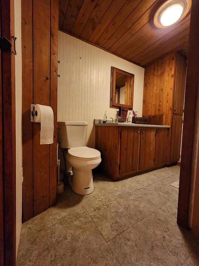 bathroom featuring wooden walls, toilet, vanity, and wooden ceiling