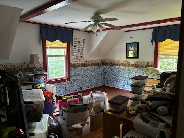 interior space with ceiling fan, a wainscoted wall, vaulted ceiling, and wallpapered walls