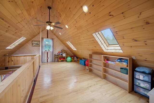 bonus room featuring lofted ceiling, ceiling fan, wooden ceiling, light hardwood / wood-style flooring, and wood walls