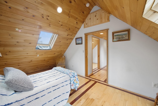 bedroom with lofted ceiling with skylight, hardwood / wood-style floors, and wooden ceiling