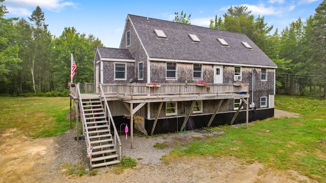 rear view of house with a wooden deck and a lawn