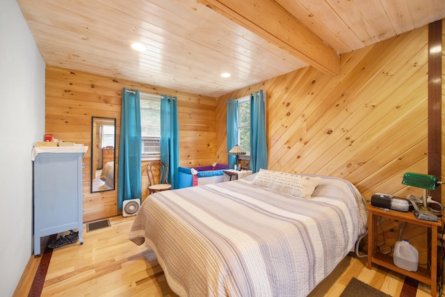 bedroom featuring wooden walls, light hardwood / wood-style flooring, beam ceiling, and wooden ceiling