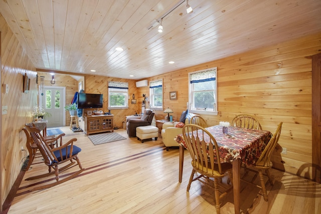 dining room with wood ceiling, wooden walls, rail lighting, light hardwood / wood-style floors, and a wall unit AC