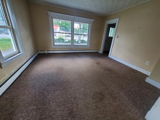 spare room featuring a wealth of natural light, carpet, and baseboard heating