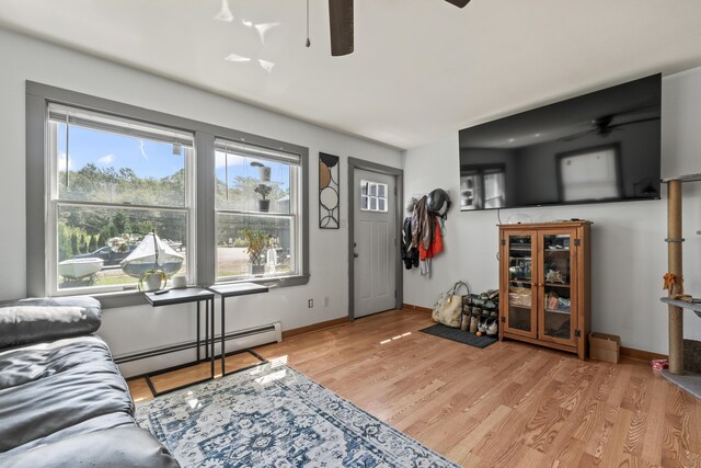 living room featuring a baseboard radiator, light hardwood / wood-style floors, and ceiling fan