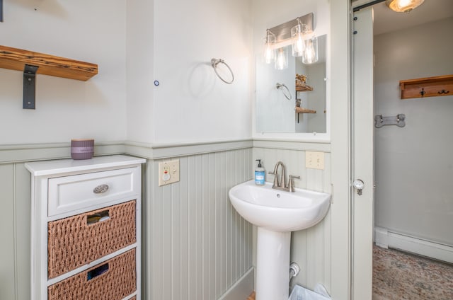 bathroom featuring baseboard heating and sink