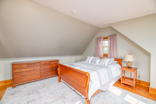 bedroom featuring light hardwood / wood-style floors and vaulted ceiling