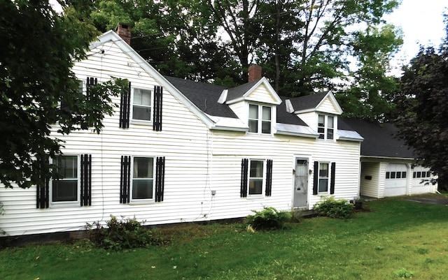 back of house with a garage and a yard