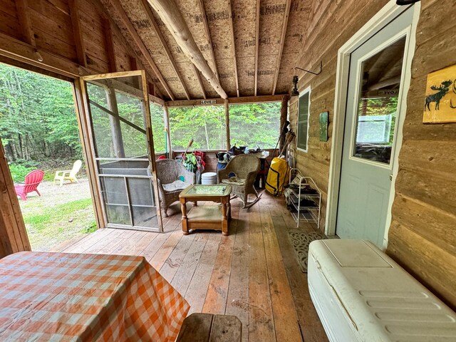 sunroom featuring lofted ceiling and a healthy amount of sunlight