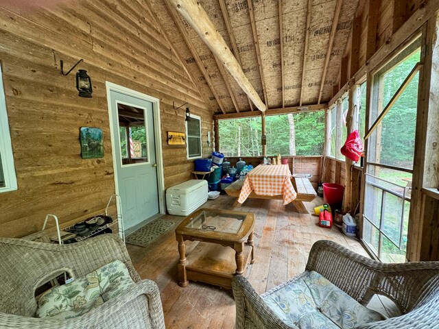 sunroom / solarium featuring lofted ceiling and a healthy amount of sunlight