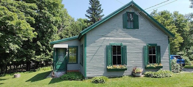 rear view of property featuring a yard