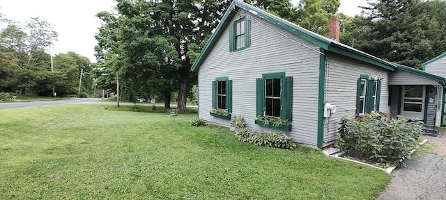 view of side of home with a yard