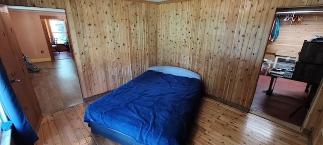 bedroom with wood walls and wood-type flooring