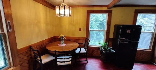 dining room with a chandelier, dark hardwood / wood-style flooring, and beamed ceiling