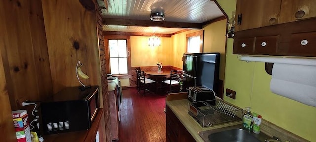 kitchen featuring sink, beamed ceiling, dark wood-type flooring, and wooden ceiling