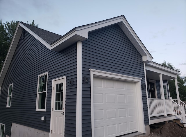 view of side of property with a garage and a porch