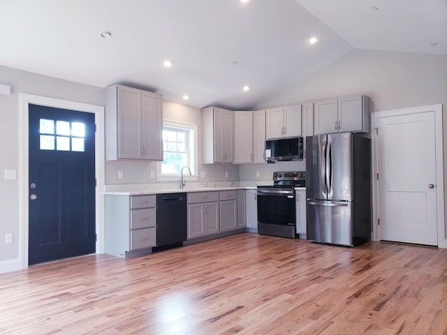 kitchen featuring gray cabinets, appliances with stainless steel finishes, high vaulted ceiling, and light hardwood / wood-style flooring