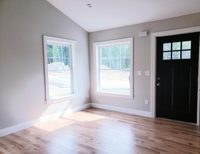 entrance foyer with light wood-type flooring, vaulted ceiling, and a healthy amount of sunlight