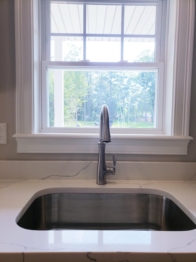 room details featuring sink and light stone counters