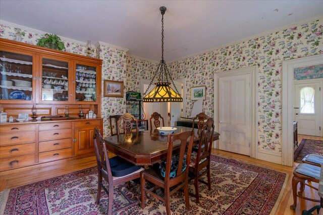 dining room with light hardwood / wood-style floors and ornamental molding