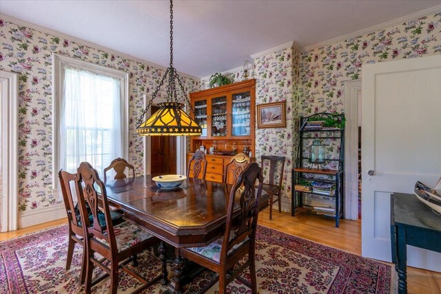 dining area featuring hardwood / wood-style flooring and ornamental molding