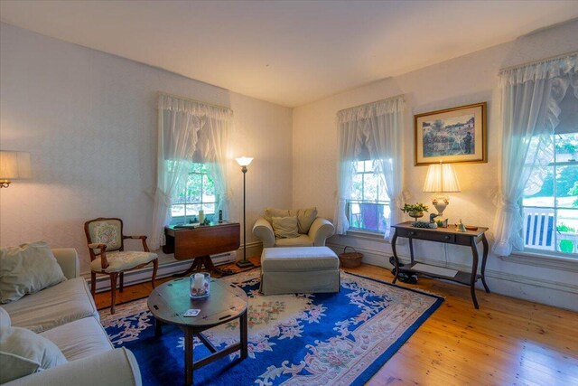 living room featuring a baseboard heating unit and light hardwood / wood-style floors