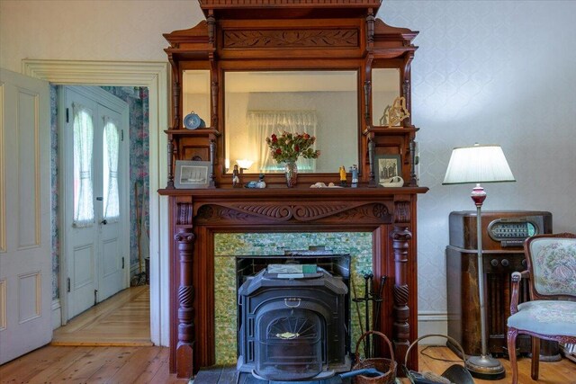 living room featuring a fireplace, a wood stove, and light wood-type flooring