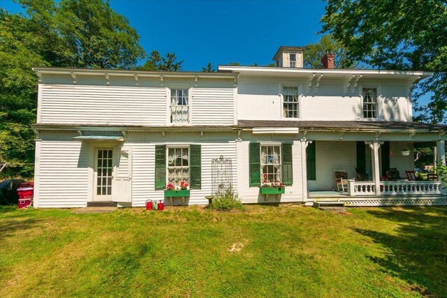 rear view of house featuring a yard