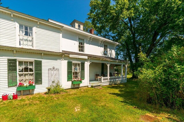 back of house featuring a yard and a porch