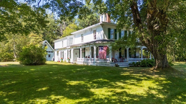 back of house featuring a lawn and covered porch