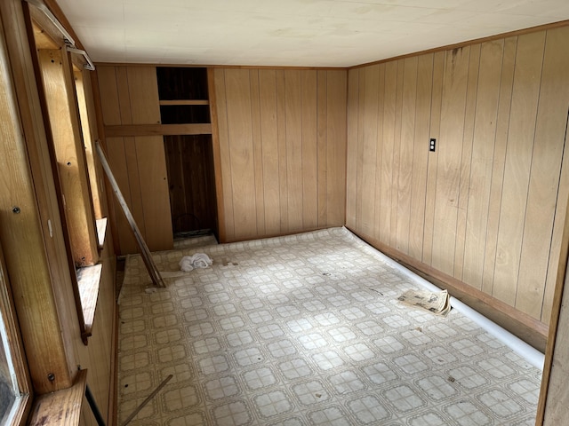 unfurnished bedroom featuring wood walls and tile patterned floors