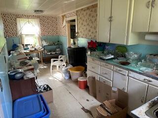 kitchen featuring wallpapered walls and a wainscoted wall