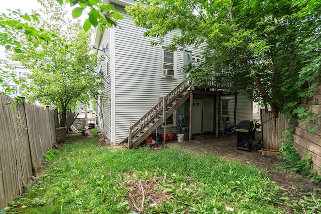 rear view of house featuring cooling unit and a wooden deck