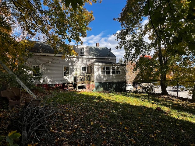 rear view of property featuring a lawn