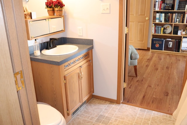 bathroom with vanity, toilet, and wood-type flooring