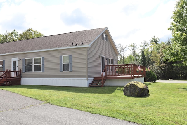 view of side of home with a yard and a deck