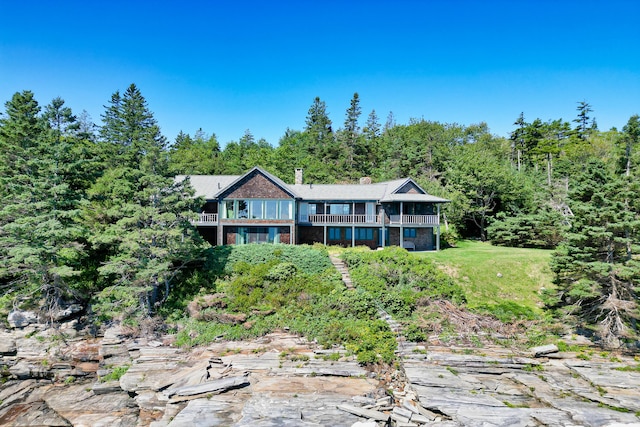 41 Sandpiper Ln, Bristol, ME 04539 - view of front of property featuring a wooded view, a balcony, and a chimney