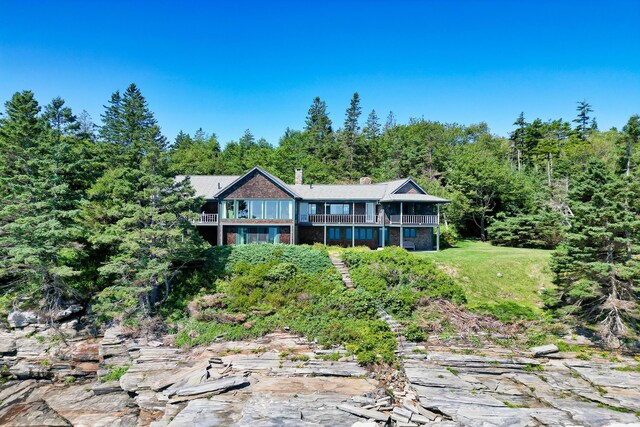 41 Sandpiper Ln, Bristol, ME 04539 - view of front of home with a chimney, a view of trees, and a balcony