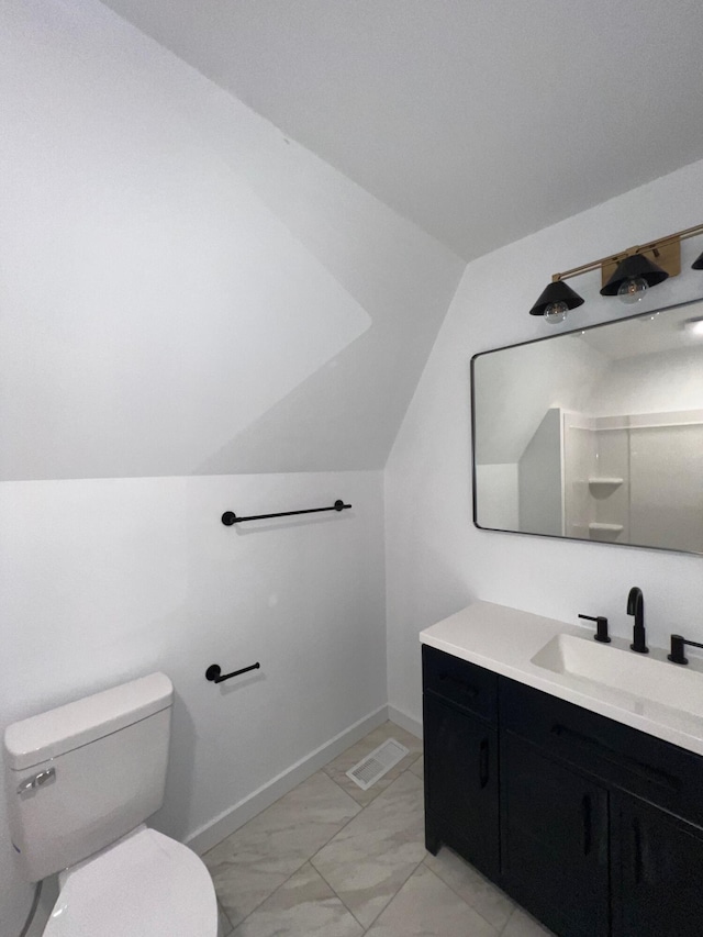 bathroom with vanity, toilet, and lofted ceiling