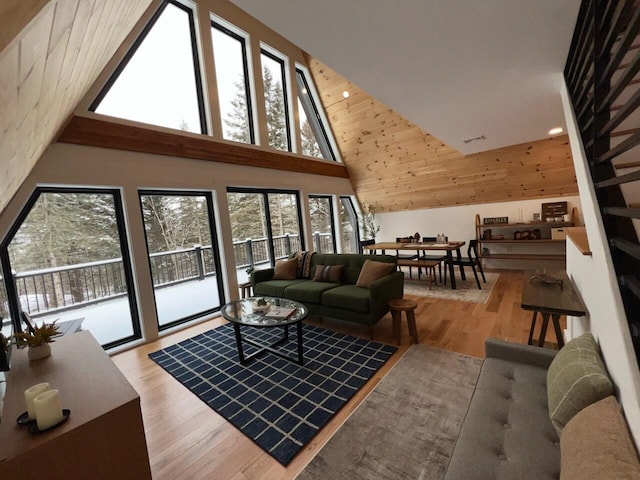 living room with light hardwood / wood-style floors and high vaulted ceiling