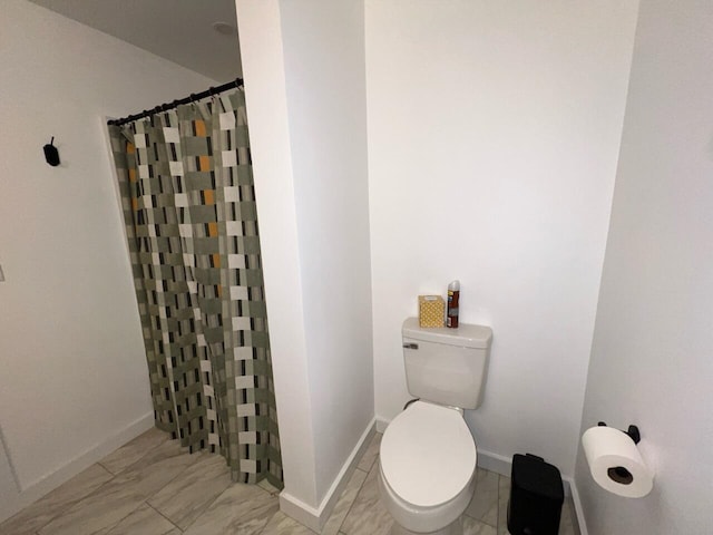 bathroom featuring a shower with shower curtain and toilet