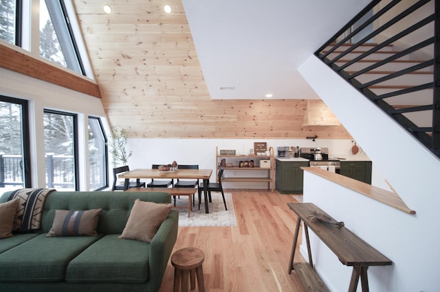 interior space with wooden walls, light wood-type flooring, and a high ceiling