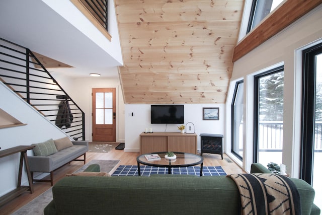 living room with light hardwood / wood-style floors and a towering ceiling