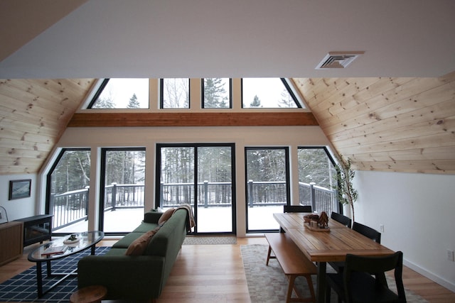 living room featuring a healthy amount of sunlight, wooden ceiling, vaulted ceiling, and light hardwood / wood-style floors