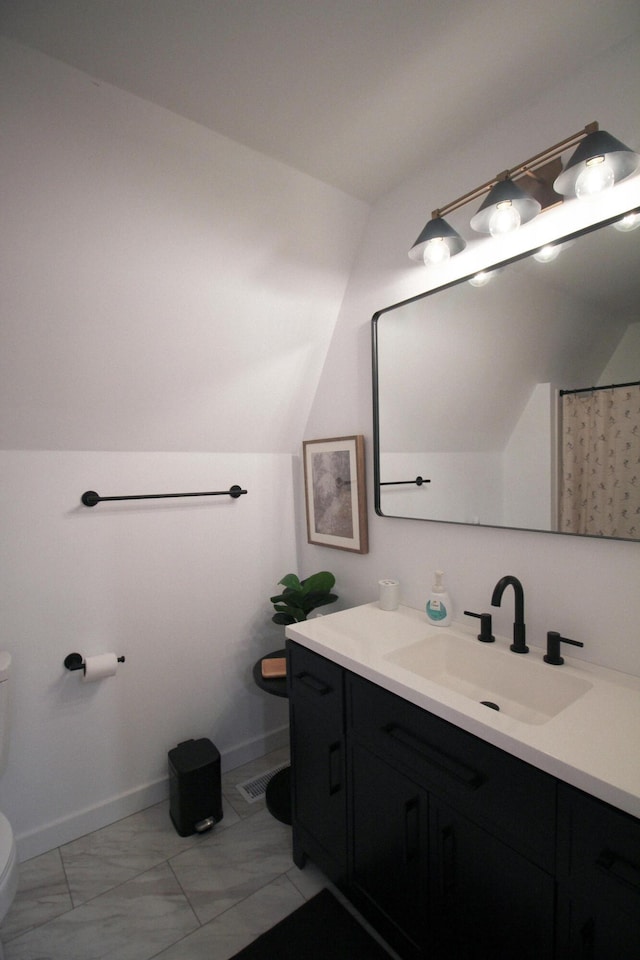 bathroom with vanity, toilet, curtained shower, and lofted ceiling