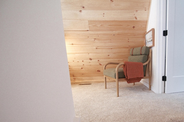 sitting room featuring carpet and wood walls