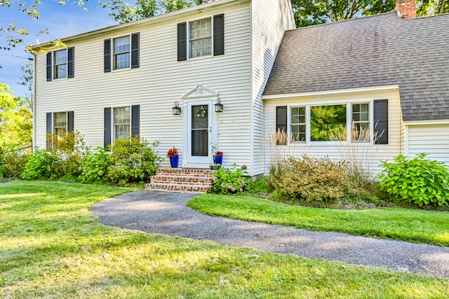 colonial-style house featuring a front yard